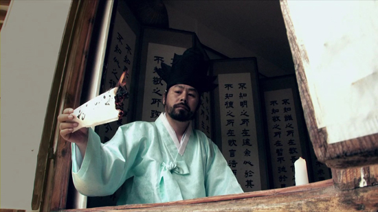 영화속 최제우 선생이 자신의 두 노비의 문서를 불사르고 있다.      &copy; 박영철