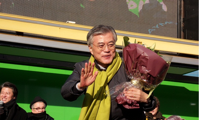 시민이 전달한 꽃다발을 안고 청중들에게 인사하는 문재인 후보