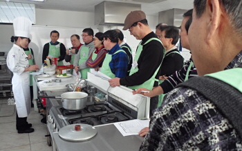 시니어 남성 요리교실 수강생들이 한국조리사관학교 김성아 교수에게 요리 강습을 받고 있다