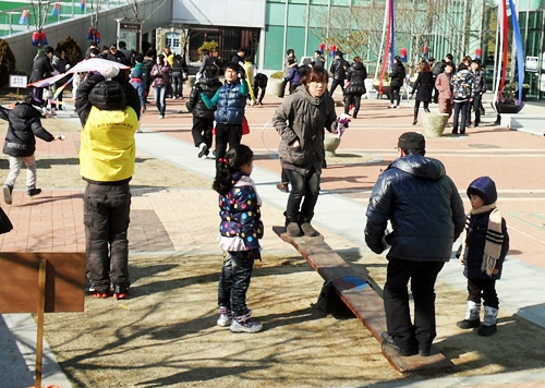 호기심 가득한 눈빛으로 널뛰기 하는 모습을 지켜보는 아이들. &copy; 조종안   