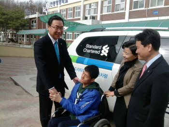 차량기증식에서 안동영명학교 재학생과 반갑게 인사를 나누는 스탠다드차타드은행 임직원들