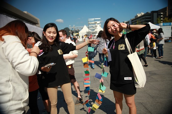 한글날을 사랑하는 대학생모임의 회원 이유진, 오누리양 등이 광화문 광장에서 시민과 어린이들의 소망과 소원을 담은 쪽지를 엮어 들어 보이며 포즈를 취하고 있다. Ⓒ안영혁