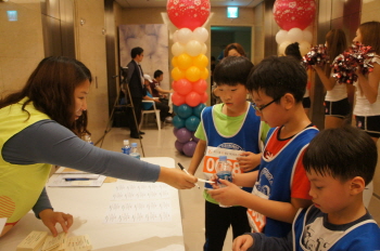 63빌딩 1층 로비에 마련된 나눔부스에서 대회참가자 한 어린이가  ‘나눔메세지’를 적고 있다