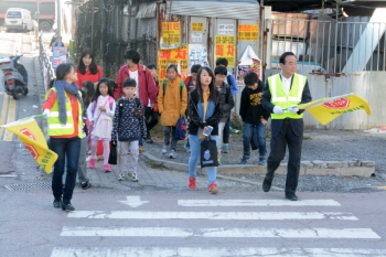 서청원 후보가 봉담초등학교 학교 앞에서 교통지도 활동을 벌이고 있다.