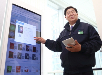 조길형 구청장이 신문 읽기 및 전자자료 확인, 열람석 예약 등 다양한 활용이 가능한 ‘스마트 라이브러리’ 기기를 시연하고 있다