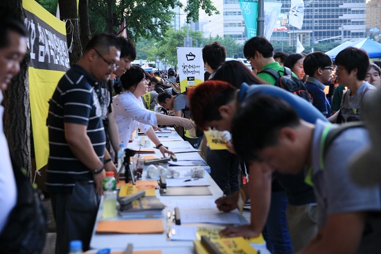 본 행사에 앞서 '세월호 특별법 제정 1000만인 서명운동’을 벌인 가운데 시민들이 '세월호 특별법 제정 1000만인 서명운동’에 동참하고 있다.