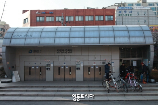 23일 영등포구청 마당 무인 자전거 주차장 옆 수리 센터에서 구민이 자전거 수리를 받고 있다.