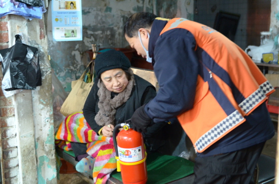 영등포 소방대원이 재래시장 점포를 방문해 소화기 사용법을 설명하고 있다. &copy;영등포소방서 