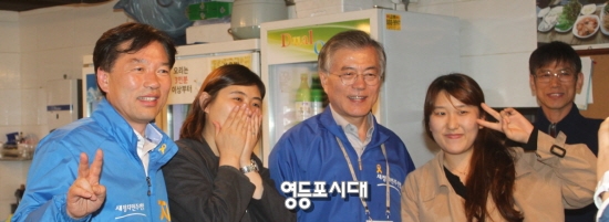 25일 문재인 대표와 함께 관악구 신림로 골목유세에 나선 정태호 후보(위 사진 왼쪽)가 구민과 사진촬영을 하고 있다. 