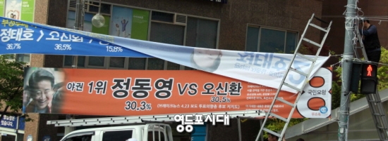 관악을 새정치민주연합 정태호 후보 측이 서울시 선거관리위원회의 현수막 철거 명령에 따라 현수막을 철거하고 있다. 