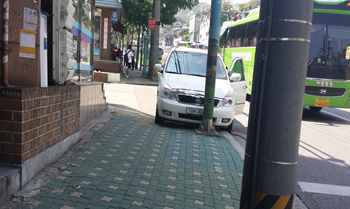 전봇대 이용해 번호판 가리고 보도위에 걸림 주차한 차량 &copy;서울시 