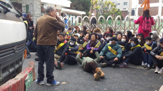 일부 지역 주민들이 발달장애학생 직업능력개발센터 공사 재개를 막기 위해 학교 앞에서 연좌농성을 벌이고 있다.