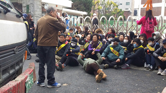 일부 지역 주민들이 발달장애학생 직업능력개발센터 공사 재개를 막기 위해  학교 앞에서 연좌농성을 벌이고 있다.