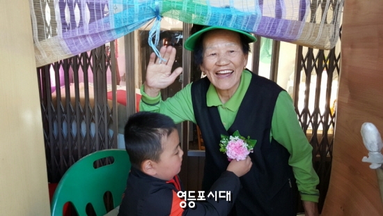 5월 4일 조성근 군이 쪽방촌 어르신께 카네이션을 달아드리고 있다.  &copy; 영등포시대 