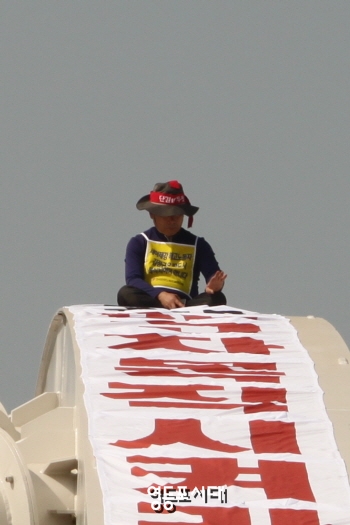 세아제강 해고노동자 김정근(60세) 씨는 4월 25일(월) 양화대교 아치 난간 끝에 올라 복직을 요구하며 ‘세아제강 해고자 복직시켜라’라고 쓰인 플래카드를 걸어놓고 농성을 벌이고 있다. &copy;영등포시대 