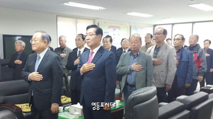 영등포구 의정회 사무실 개소식에 참석한 정진원 의정회 회장(사진 왼쪽)과 이용주 영등포구의회 의장 등 관계자들이 국기에 대한 경례를 하고 있다. ©영등포시대 