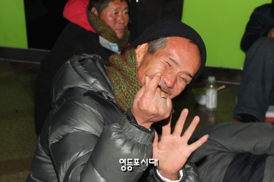 영등포역 노숙인이 전달 받은 목도리를 걸고 밝은 모습으로 자세를 취하고 있다. ⓒ영등포시대  