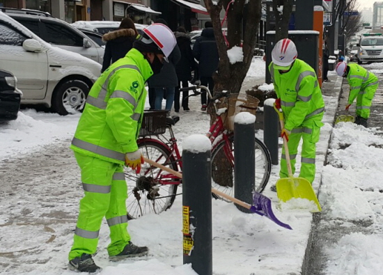 20일 오전 영등포 공무관 유상 씨(사진 앞쪽)가 영등포구청 건너편에 쌓인 눈을 동료들과 치우고 있다. &copy;영등포시대 