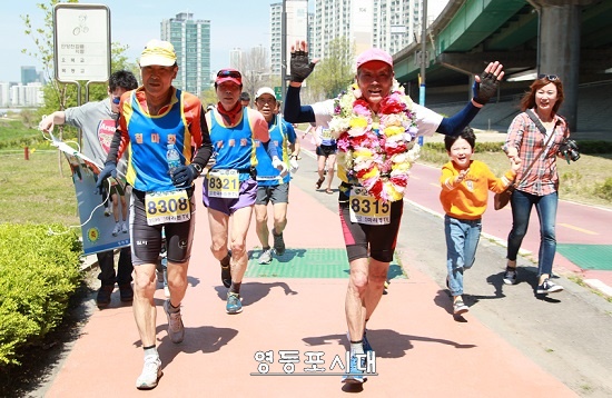 80세 고령에도 불구하고 공인마라톤 대회에서 500회 완주를 성공한 장재연 어르신(사진 오른쪽)이 두 손을 번쩍 들어 보이고 있다. Ⓒ영등포시대 