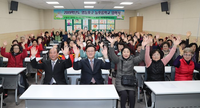 ‘2019학년도 늘푸름학교 입학식’에 참석한 윤준용 의장(사진 왼쪽)과 채현일 구청장(사진 두 번째)이 어르신 신입생들과 축하의 구호를 외치고 있다. 