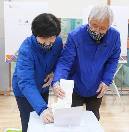 더불어민주당 영등포갑 국회의원 후보(사진 왼쪽)가 11일 당산2동 주민센터에 설치된 사전투표소에서 배우자와 함께 투표하고 있다. 