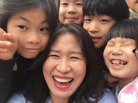 ▲쪼물왕국지역아동센터 이인숙 원장(사진 가운데)과 아이들 