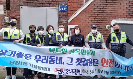 ▲당산1동 골목길에 주민의 안전과 화재 예방을 위해 보이는 소화기를 설치한 당산1동 자율방범대(대장 허승교 사진 왼쪽에서 다섯 번째) 대원들과 서연남 동장(오른쪽에서 세 번째) 등이 기념사진을 찍고 있다. Ⓒ영등포시대