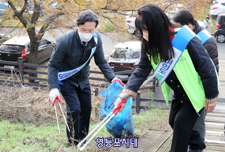 ▲‘여의도 샛강 줍깅데이’에 참석한 채현일 구청장(왼쪽)과 이섬숙 주민자치회장(오른쪽)이 쓰레기를 줍고 있다. Ⓒ영등포시대