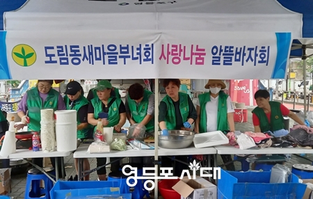 ▲도림동 새마을부녀회가 13일 비가 쏟아지는 가운데 도림 고가 밑에서 ‘사랑 나눔 알뜰바자회’를 열고 부침개, 의류 등을 판매하고 있다. Ⓒ영등포시대