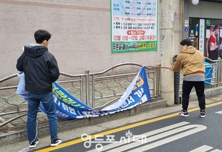 ▲신길7동 주민센터 직원들이 불법 현수막을 철거하고 있다. Ⓒ영등포구