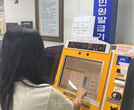 ▲ 당산2동 무인민원발급기에서 부동산등기사항 증명서를 발급받고 있는 모습/이미지=영등포구 제공 
