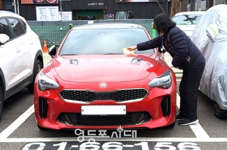 ▲영등포구 주차단속원이 거주자 우선주차구역 내 무단주차 차량에 단속예고작을 부착하고 있다. /이미지=영등포구 제공
