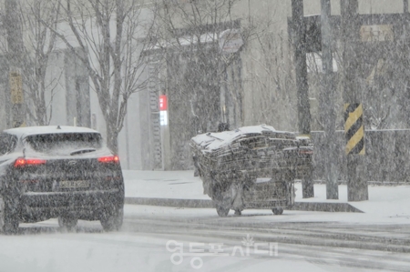 ▲한 치 앞도 분간하기 어려운 폭설이 쏟아진 2월 6일 오후, 한 어르신이 파지를 잔뜩 실은 손수레를 끌고 고물상으로 이동하고 있다. Ⓒ영등포시대