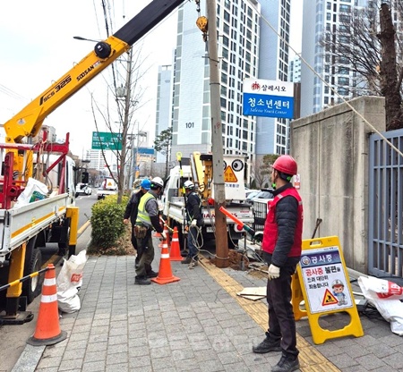 ▲3월 21일 대림1동 주민센터 맞은편 인도 중앙에 위치한 통신주를 철거하고 있다. ©영등포구 제공