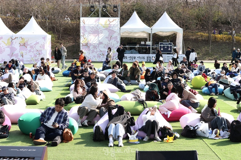 ▲‘2025 영등포 여의도 봄꽃축제’ 첫날인 8일 오후 한강공원 특설무대 앞에서 시민들이 빈백에 앉아 여유로운 쉼을 즐기고 있다. ©영등포시대