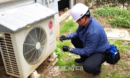 ▲영등포구 관계자가 에어컨 실외기에 차양막을 설치하고 있다. ⓒ영등포구 제공