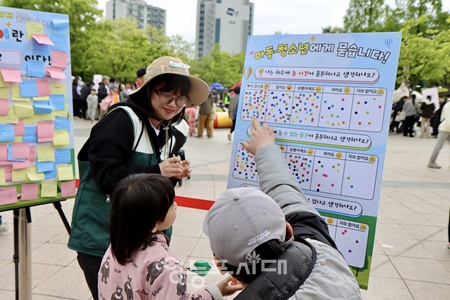 ▲초록우산 영등포종합사회복지관가 5월 3일 영등포공원에서 개최한 어디든 놀이터 ‘마음 쉼 캠핑 놀이터’에서 놀 권리 인식 조사를 하고 있다. ©영등포종합사회복지관 제공