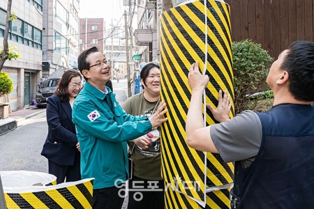 ▲최호권 영등포구청장이 어린이집 앞 전신주에 안전보호대를 설치하고 있다. ©영등포시대