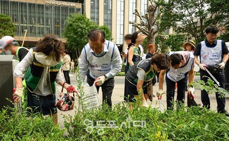 ▲한국교직원공제회 임직원들과 영등포구 여의도동 지역주민들이 7월 2일 여의도역 인근에서 환경정화 활동을 펼치고 있다. ⓒ:한국교직원공제회 제공