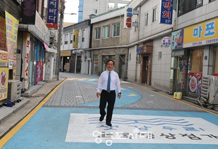 ▲박남일 샛강두리골목상인회 회장이 샛강을 연상시키는 강줄기와 부흥을 기대하는 그림이 그려진 길을 걷고 있다. Ⓒ영등포시대