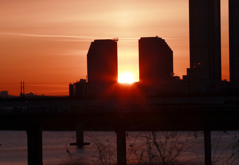 ▲2026년 1월 1일 7시 44분을 전후해 새해 첫해가 여의도 쌍둥이 빌딩 사이로 솟아오르고 있다. ⓒ영등포시대