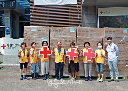 ▲적십자봉사원들이 서울 양천구 서부봉사관에서 홀몸어르신에게 전달될 선풍기 앞에서 기념촬영을 하고 있다. ©대한적십자사 서울시지사 제공